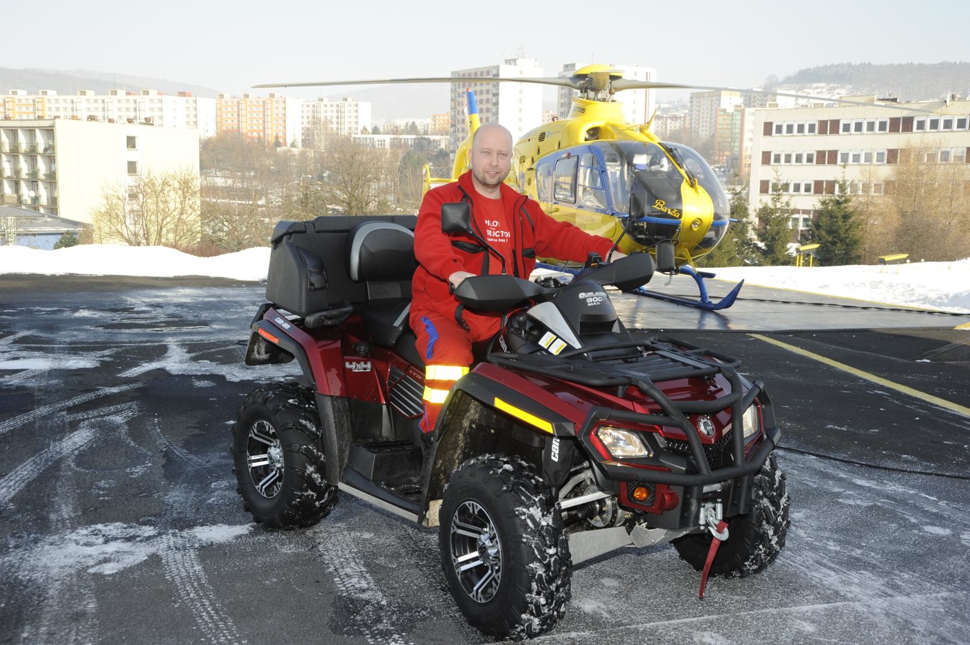 On a quad bike at the helipad, helicopter in the background